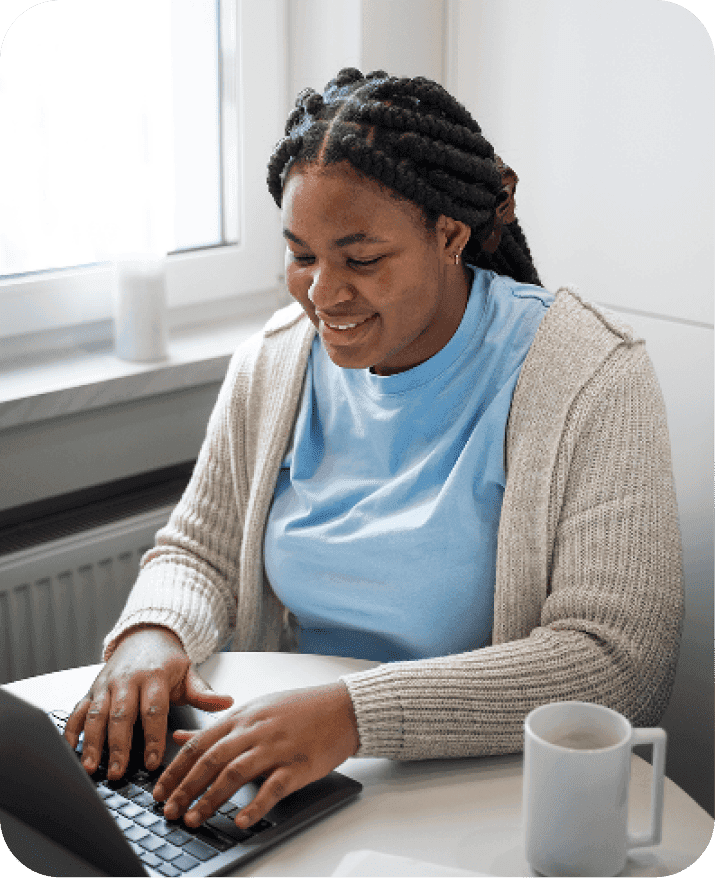 A person sitting comfortably at home while using a laptop for a telemedicine consultation.